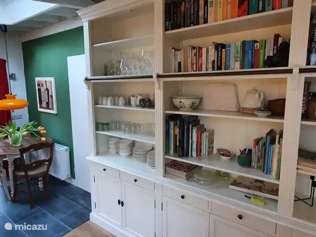 vakantiehuis huren in Nederland, Overijssel, Giethmen – Vakantiehuisje in Giethmen Grote boekenkast waarin ook servies en spelletjes. Zicht op klein zitje bij de keuken en deur naar 3e slaapkamer.