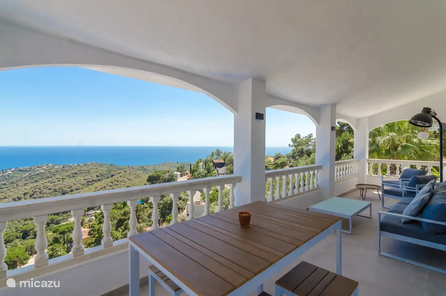 Schöner großer Balkon mit gemütlichem Sofa und Blick auf die schöne Bucht von Cala Canyelles