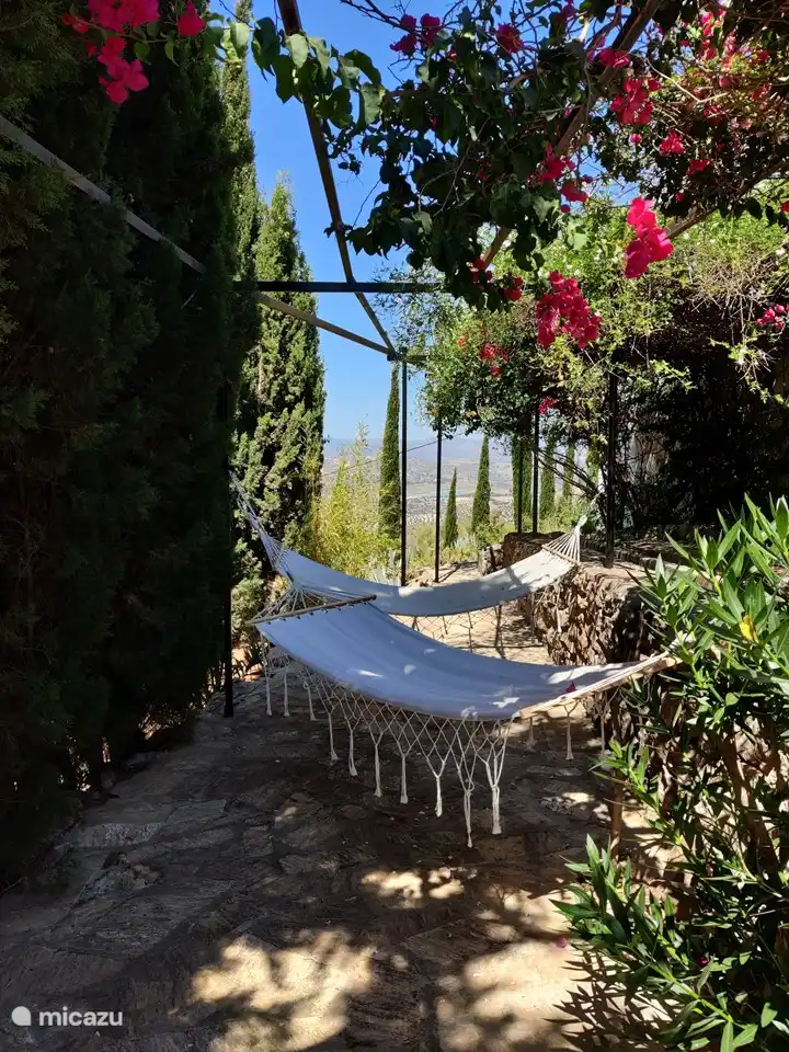 Eine Etage tiefer im Garten können Sie in der Hängematte zwischen den Zypressen eine Siesta machen.