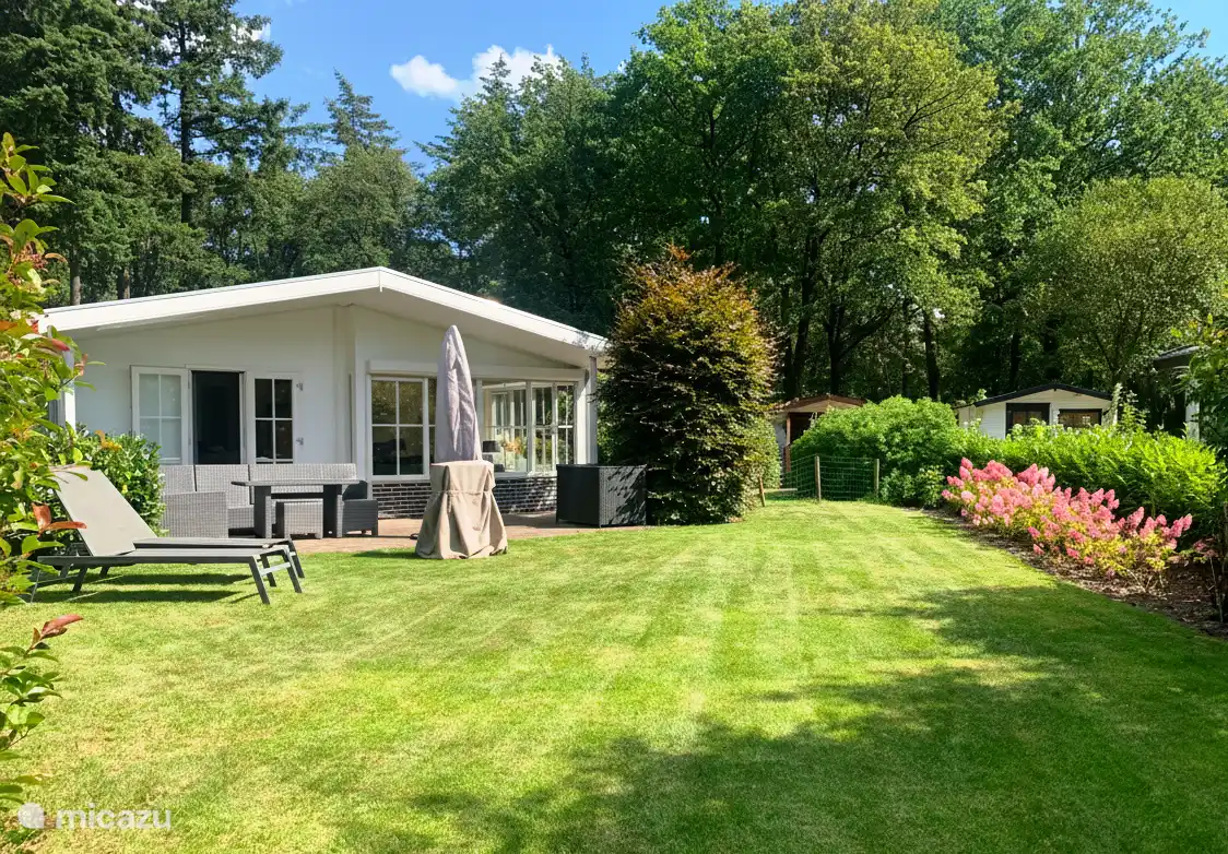 De ruime tuin gezien vanaf de vijverkant