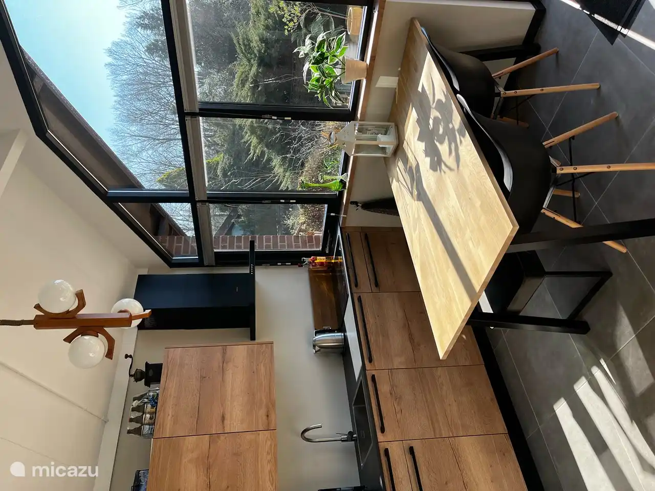 Desde la cocina se tiene una vista del jardín. La mesa de comedor tiene un banco y dos sillas. Si sois cinco o seis, hay dos sillas plegables abajo que se pueden juntar.