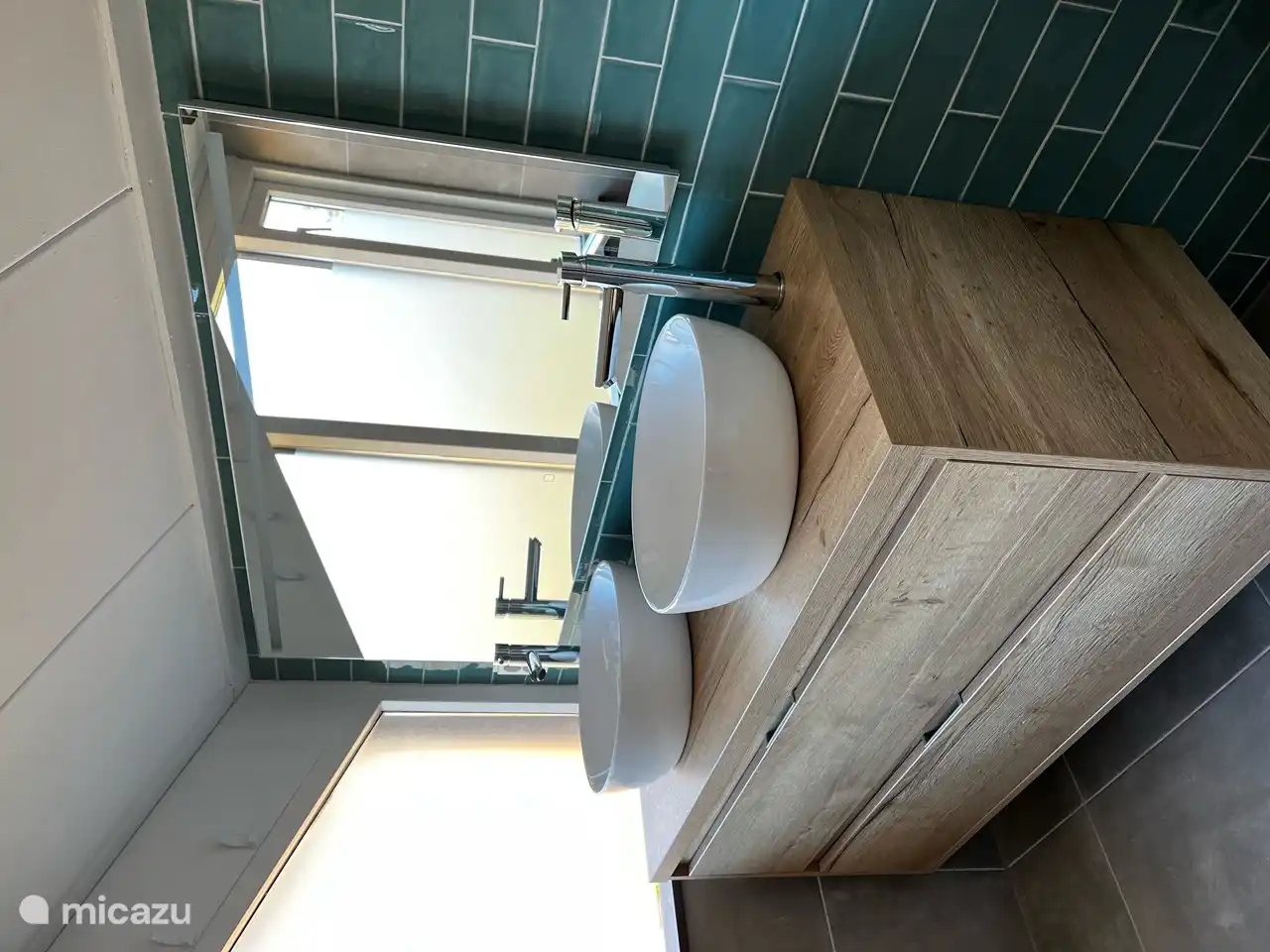 El baño está elegantemente decorado y tiene un lavabo con dos cajones grandes y dos lavabos.