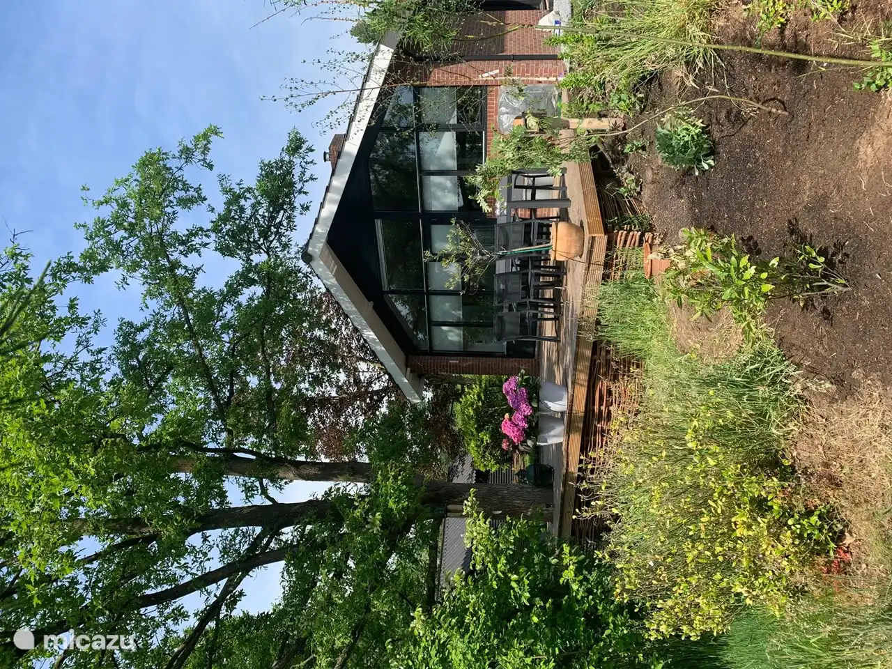 Detrás de la casa hay una terraza maravillosamente grande que da al gran estanque del parque de vacaciones.