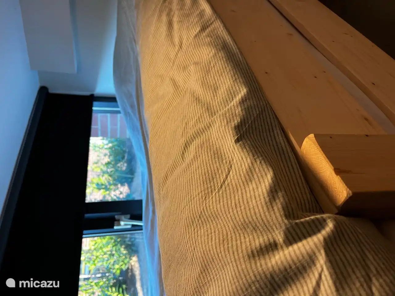 La cama superior da a la vegetación del lado del jardín a través de la ventana.