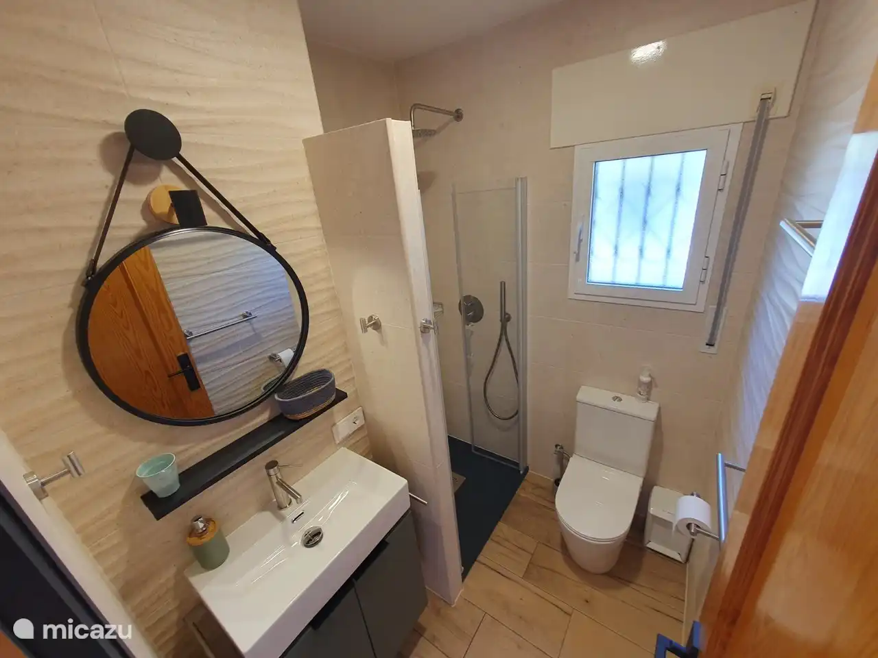 Das zweite Badezimmer mit Regendusche, Waschbecken und Toilette.