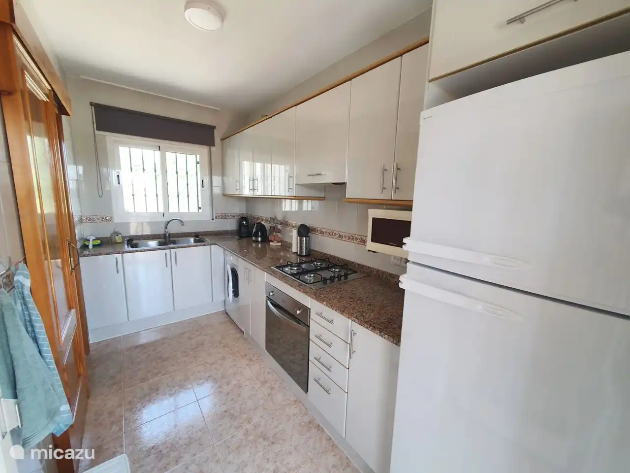 Küche, die mit verschiedenen Geräten, Besteck, Kochutensilien usw. ausgestattet ist.