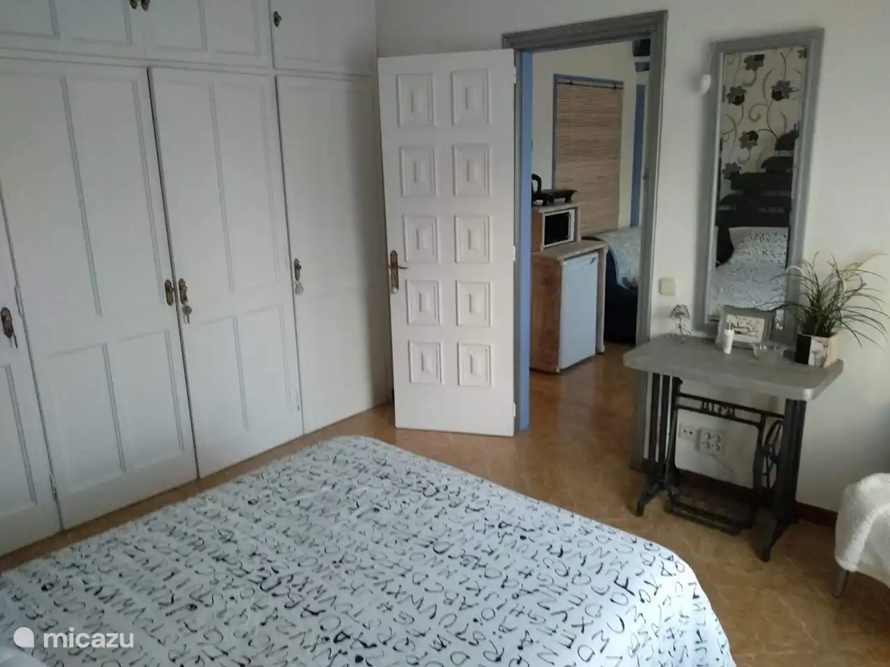 Blick vom Schlafzimmer mit Einbauschränken auf das Wohnzimmer. Schminktisch mit Spiegel