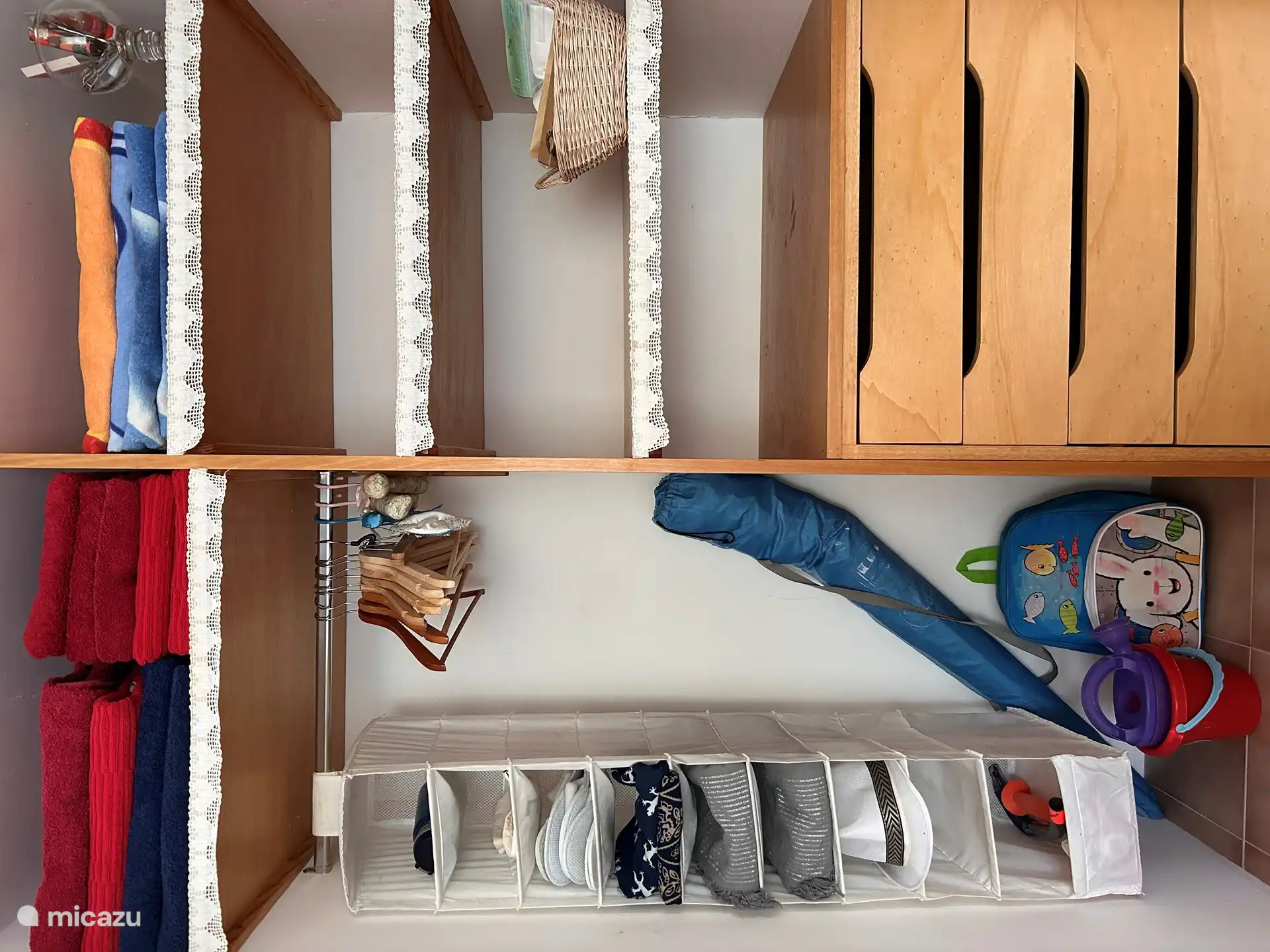 Geräumiger Kleiderschrank mit Handtüchern, Strandtüchern, Pareos und Strandrucksack mit Spielzeug für die Kinder 
