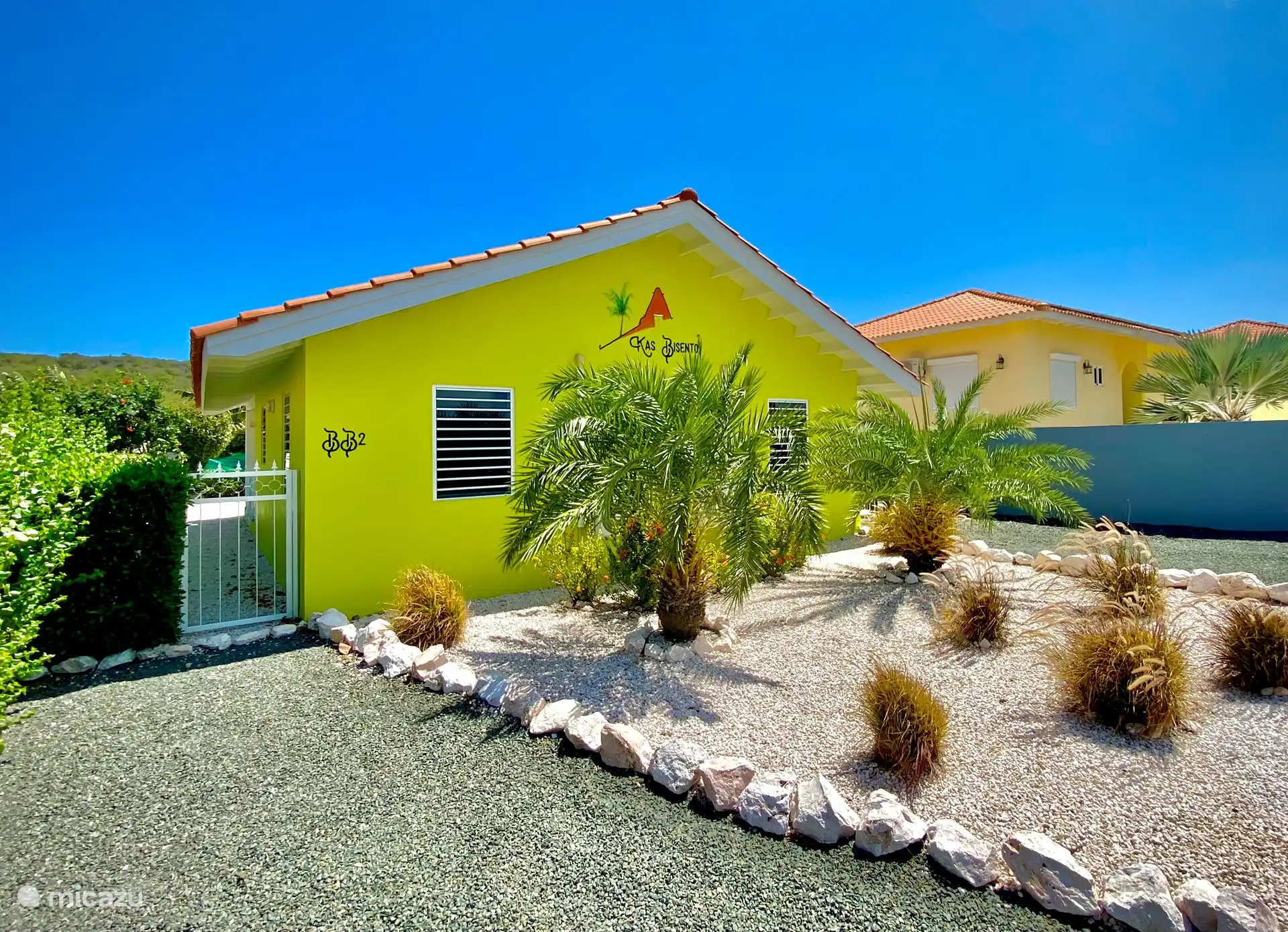 Vue de la rue Kas Bisento. Deux allées, donc assez d’espace pour une voiture et éventuellement des visiteurs. Parce que l’arrière de la maison est dans la rue, vous avez beaucoup de paix et d’intimité sur le porche, dans la piscine et le jardin.