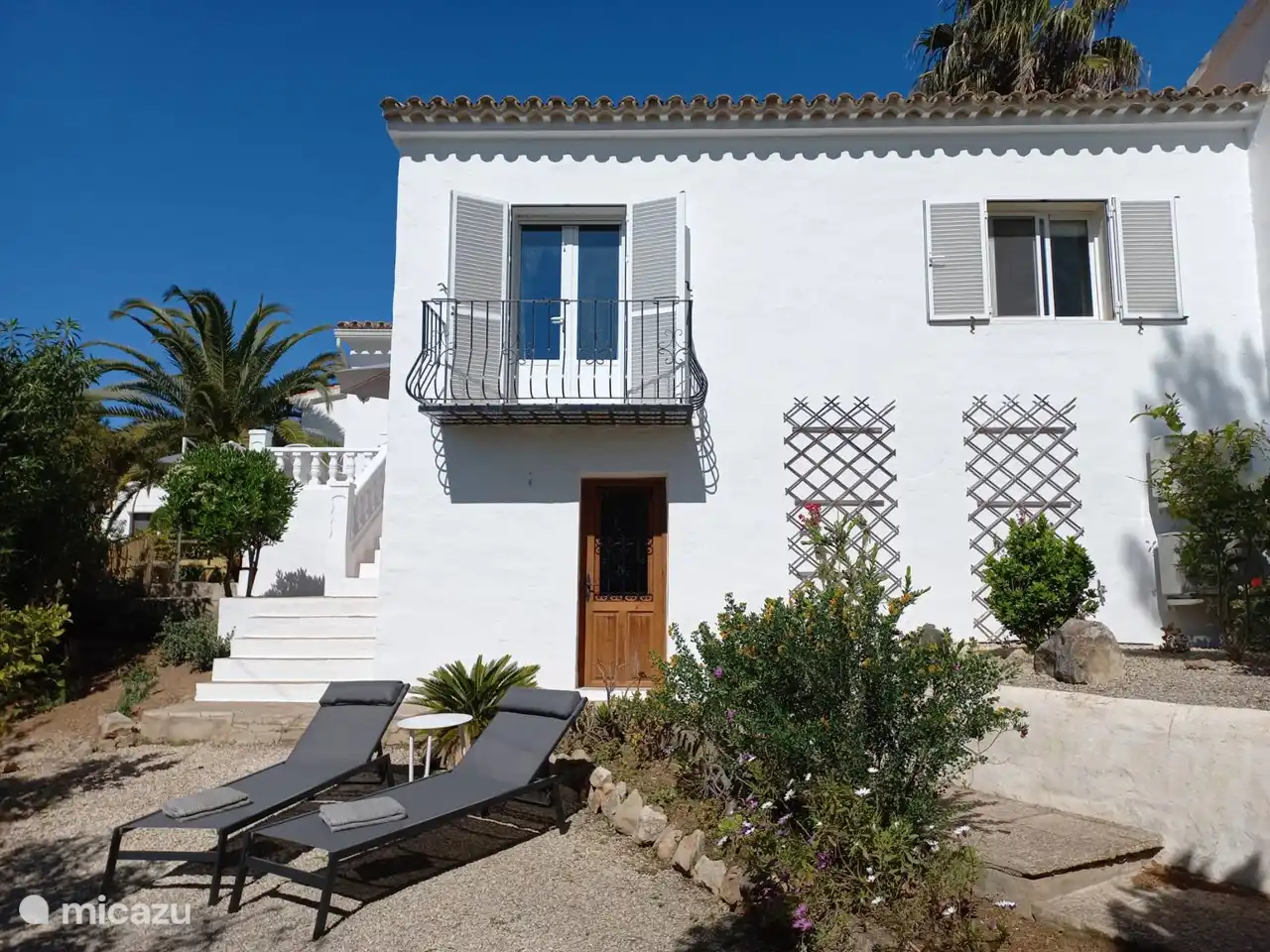 La façade et les (trois !) terrasses : 1 terrasse lounge, 1 terrasse avec table de pique-nique et une terrasse avec transats.