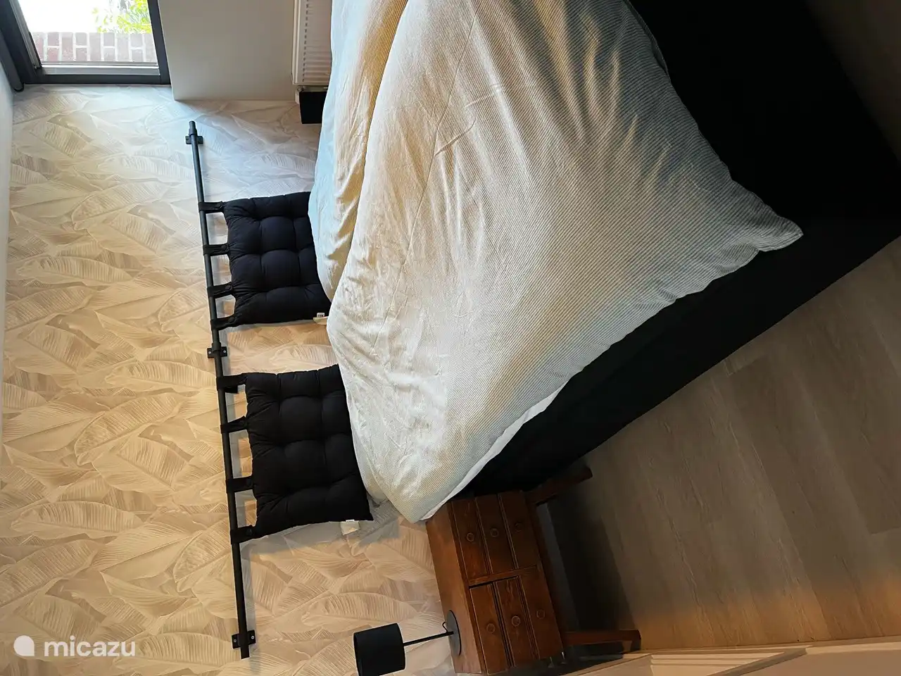 Im Sommer ist das Schlafzimmer im Souterrain herrlich kühl. Das Fenster blickt auf das Grün des Gartens an der Seite des Hauses.