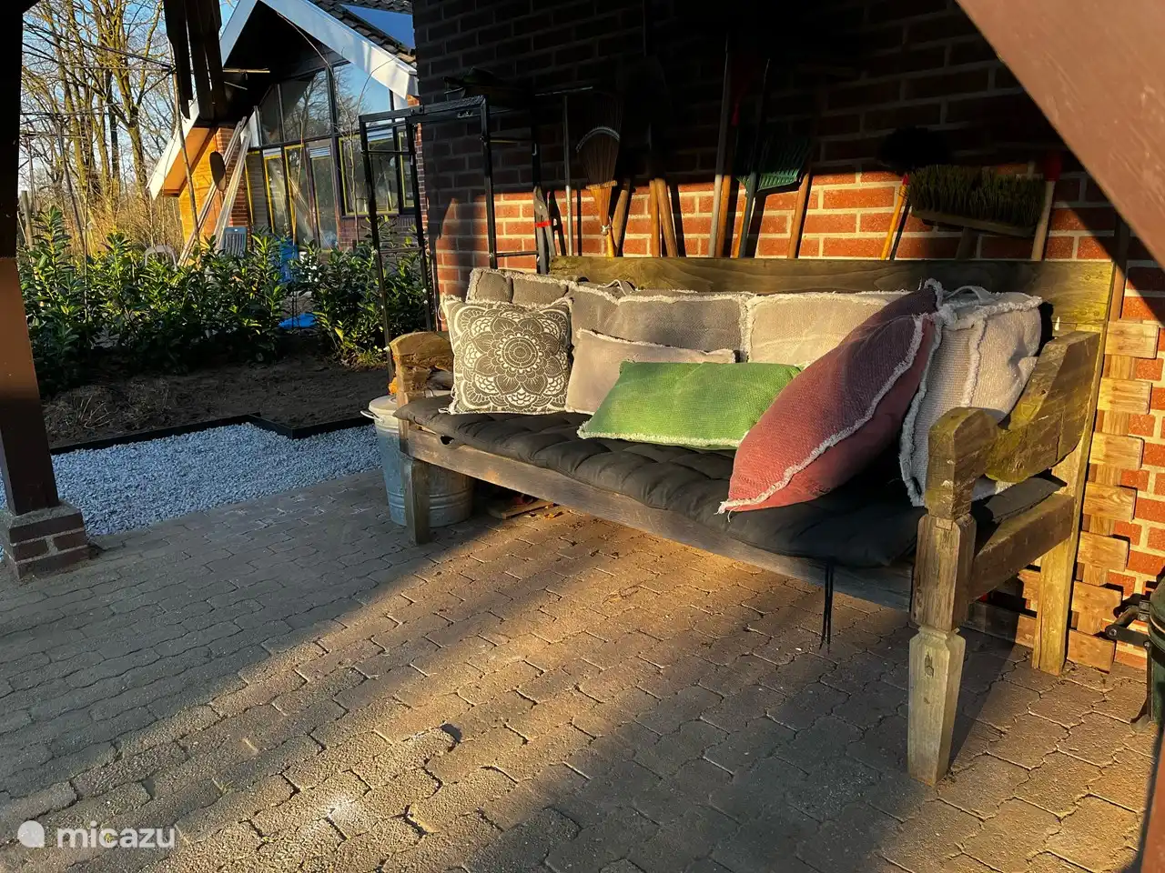 Unter dem Dach neben dem Haus befindet sich ein Lounge-Sofa, auf dem Sie sich entspannen können.