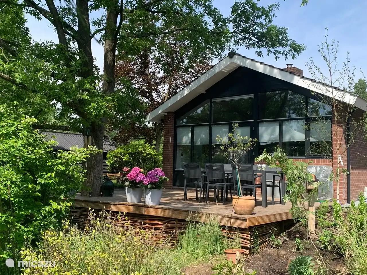 Hinter dem Haus befindet sich eine wunderbar große Terrasse mit Blick auf den großen Teich des Ferienparks.