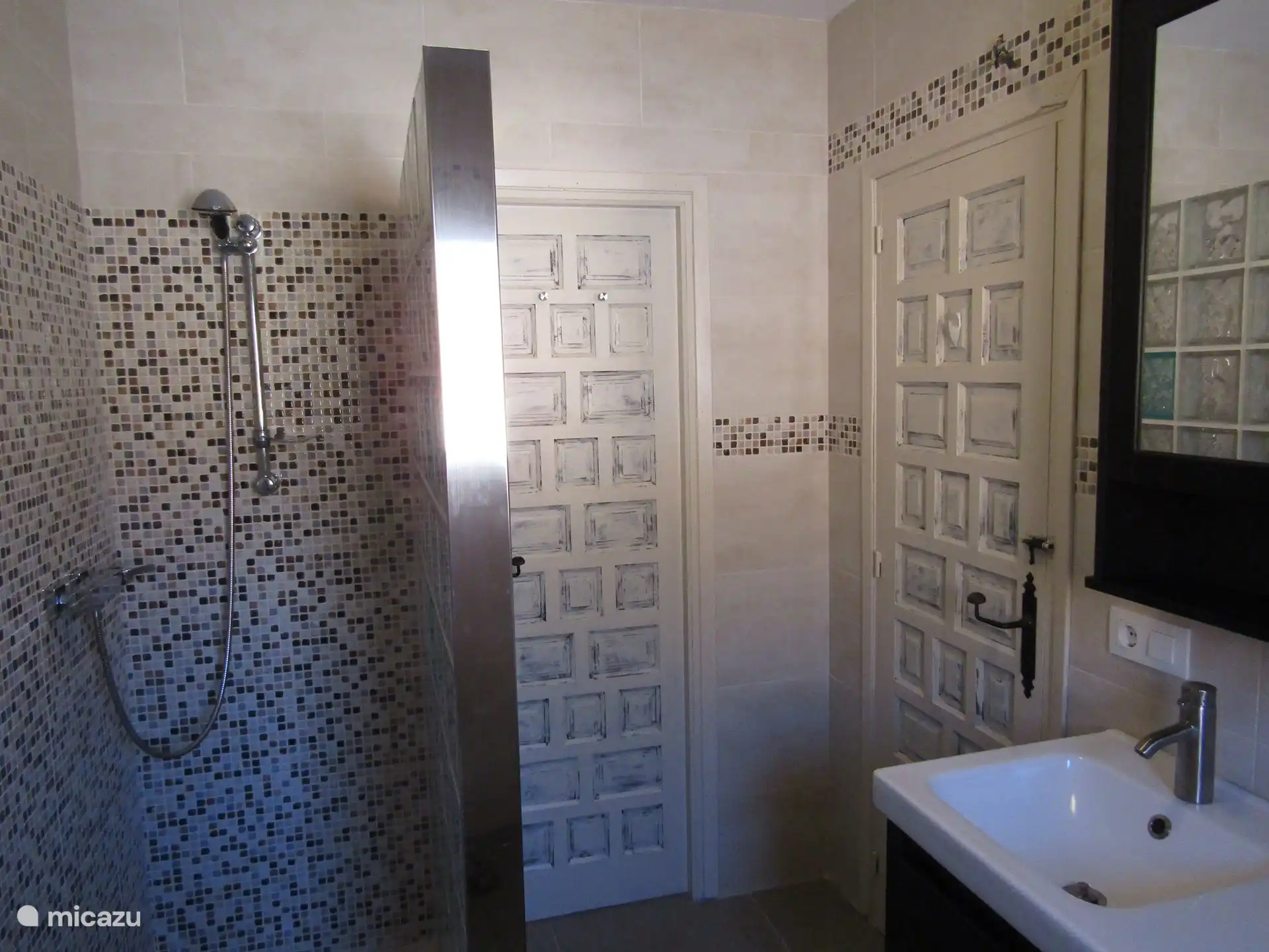 La deuxième salle d'eau avec douche à l'italienne et double vasque. La machine à laver se trouve également ici.