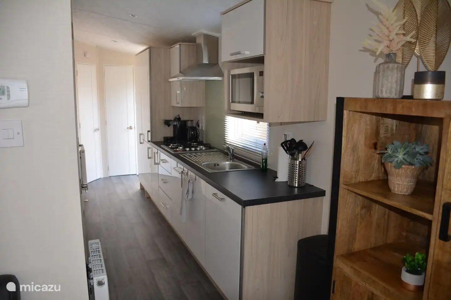 Keuken met vaatwasmachine, combimagnetron, koel-vriescombinatie, senseo switch, waterkoker en genoeg kastruimte om je boodschappen in op te bergen. 