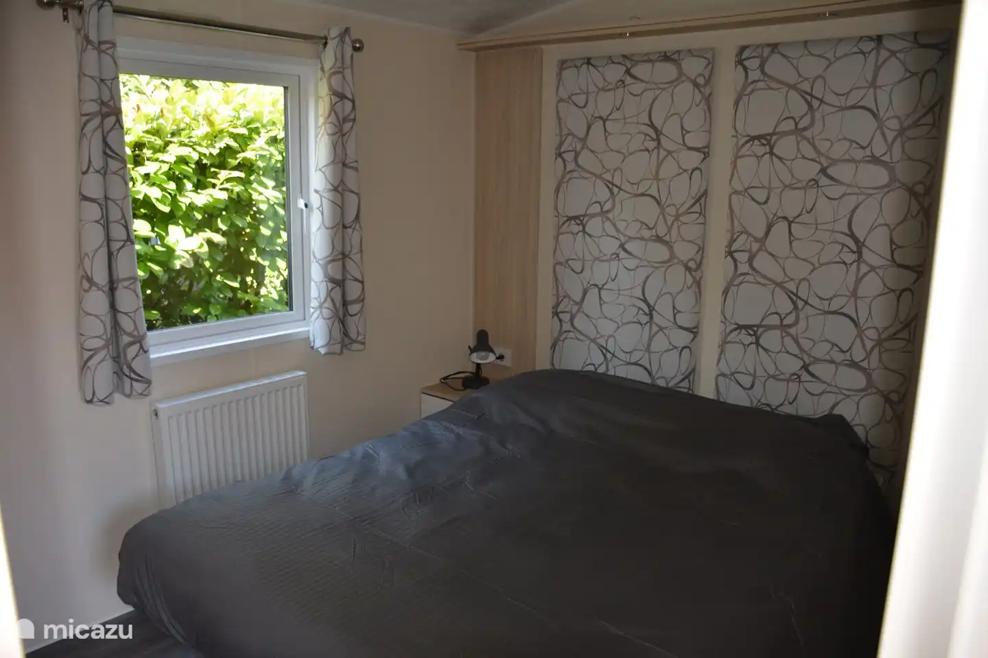 Slaapkamer met een tweepersoonsbed, 2 ruime kasten, nachtkastjes met nachtlampjes. De bedden zijn opgemaakt bij aankomst. 