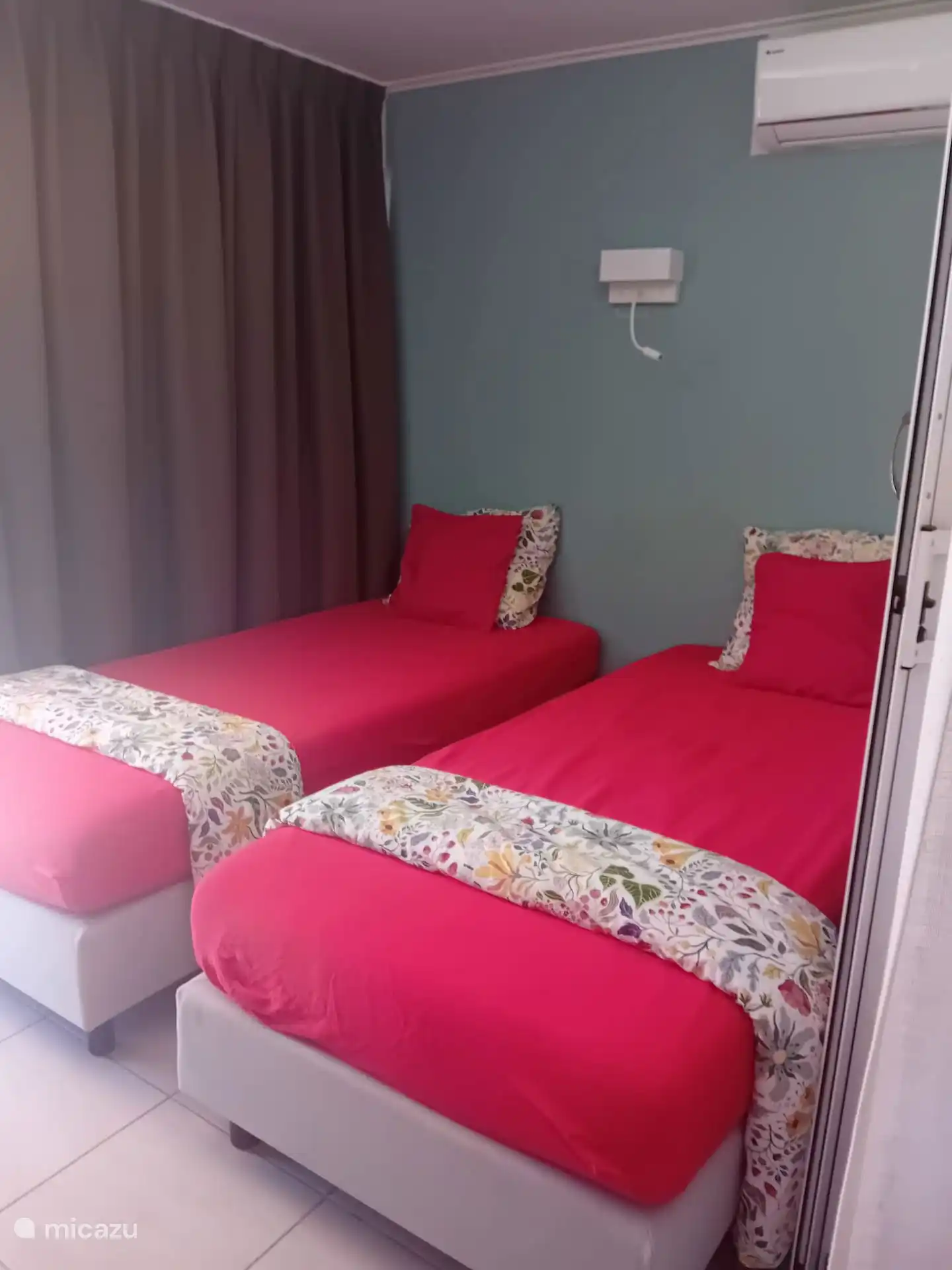 Schlafzimmer mit zwei Boxspringbetten und Klimaanlage. 