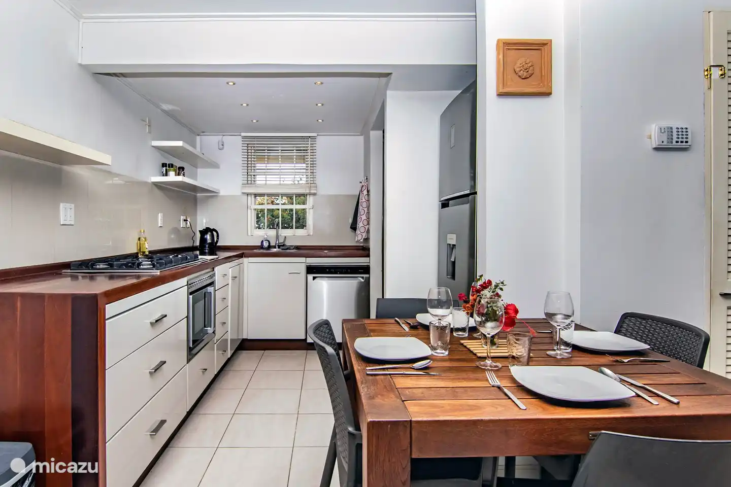 Sehr moderne Küche mit Geschirrspüler, Mikrowelle, 5-Flammen-Herd, großem Kühlschrank und ausgestattet mit Tellern, Besteck, Pfannen und Töpfen.