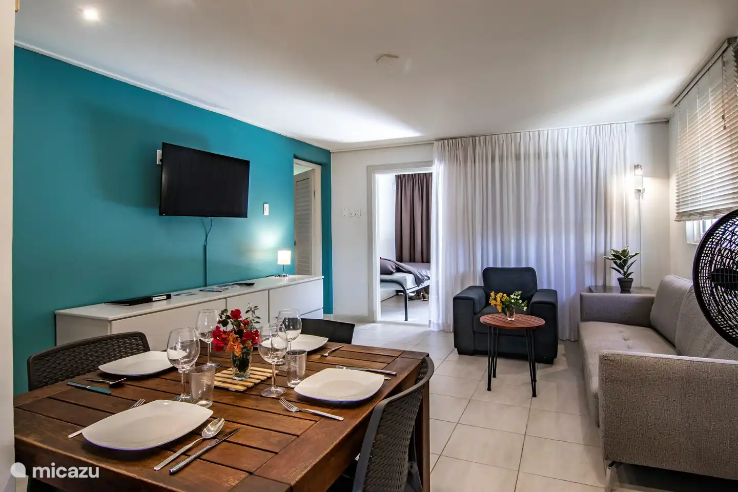 Die Sitzecke im Wohnzimmer. Ein bequemer Sessel und ein schönes, gut sitzendes Sofa mit Couchtisch. Hier gibt es eine Klimaanlage und einen Ventilator. Sie können den Fernseher mit IDtv (alle gewünschten Sender) nutzen oder ein gutes Buch lesen oder sich ein Spiel aussuchen.