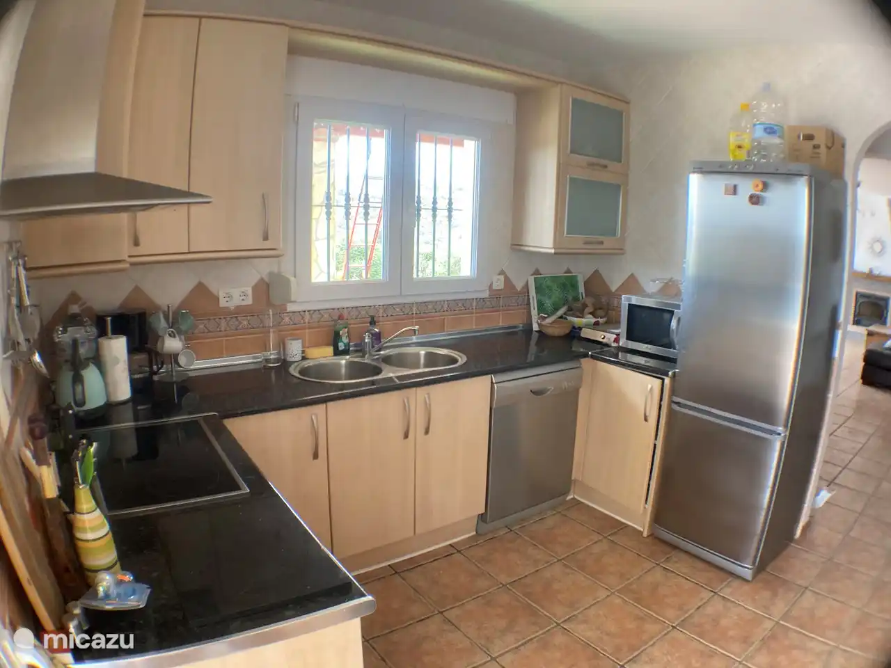 A kitchen that is fully equipped; oven, hob, dishwasher, kettle, coffee maker, fridge-freezer, microwave, toaster, smoothie maker, mixer, stone grill/gourmet and, of course, crockery with a palm motif