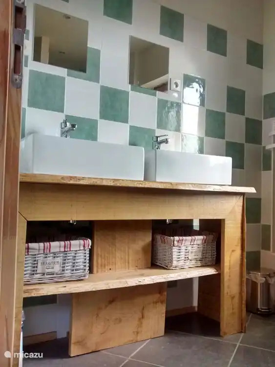 De ruime badkamer heeft twee wastafels.