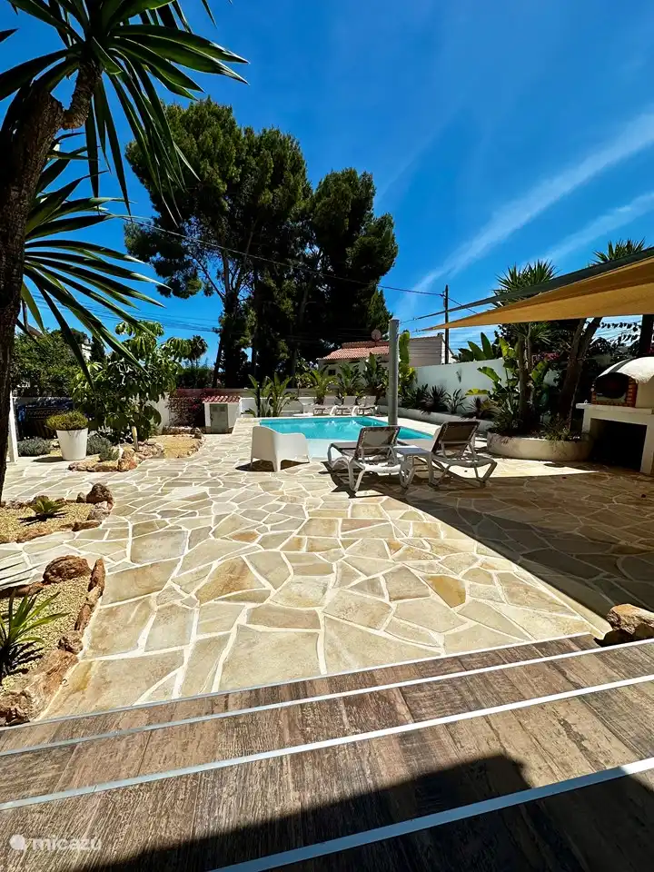 Der Garten mit Swimmingpool und Außenküche. 