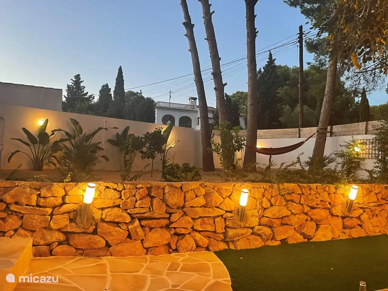 Entspannen Sie sich bei Einbruch der Dunkelheit in der Hängematte im großen Garten.