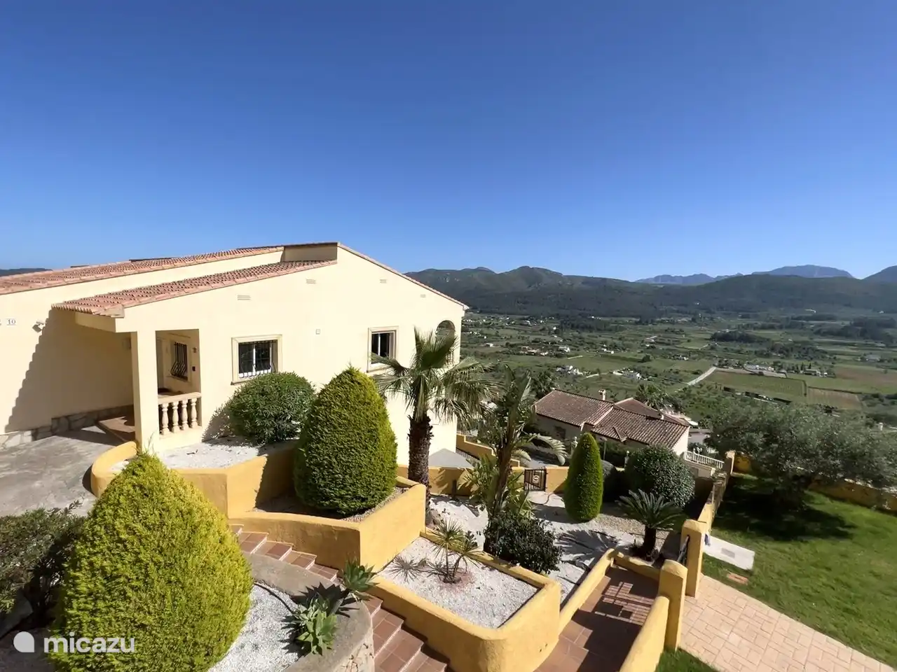 Seite des Hauses mit gepflegtem Garten.