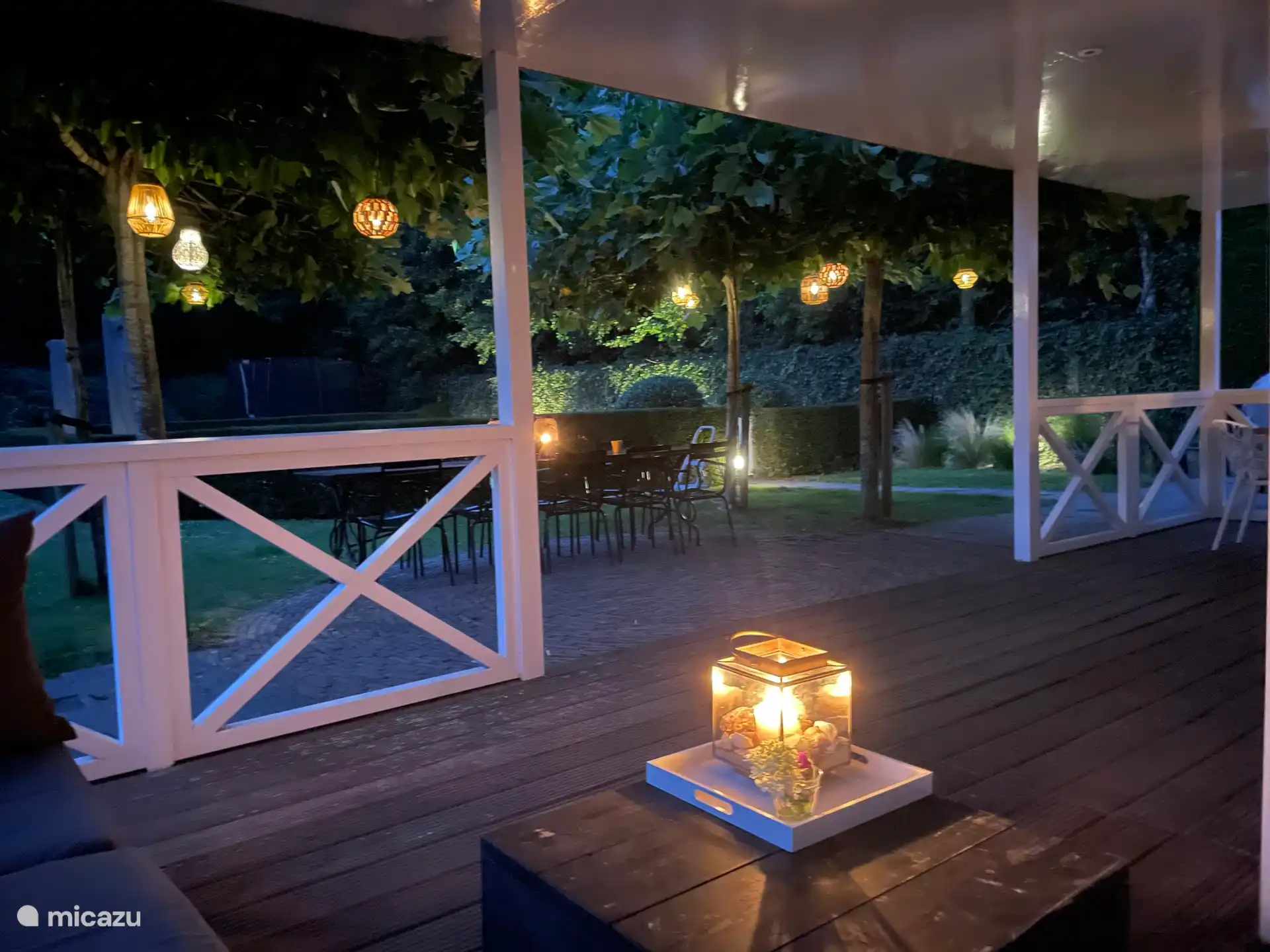 Abendlicher Blick auf den Garten von der Lounge-Garnitur auf der Veranda