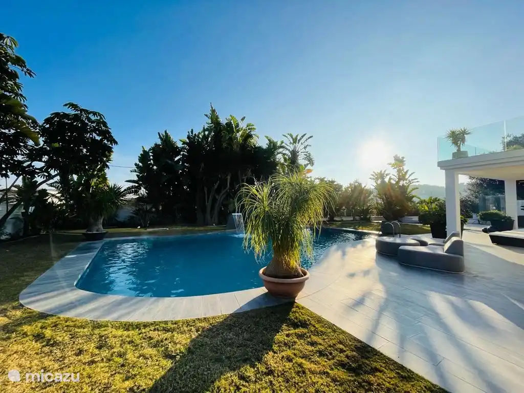 Zicht op tuin, terras en zwembad vanaf de rechterkant van de tuin