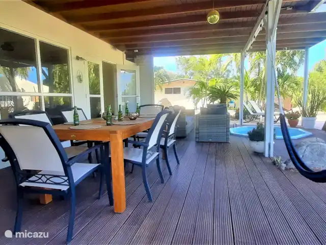 Villa de lujo con hermoso jardín en Aruba, Paradera, Paradera - villa Veranda con jacuzzi, mesa de comedor y juego de salón.