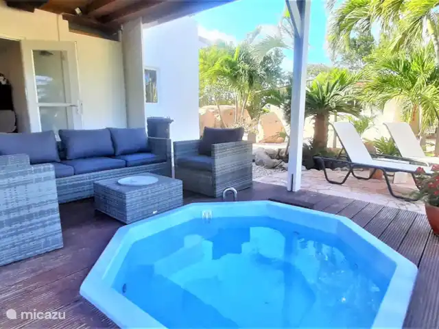 Villa de lujo con hermoso jardín en Aruba, Paradera, Paradera - villa Veranda con jacuzzi, mesa de comedor y juego de salón.
