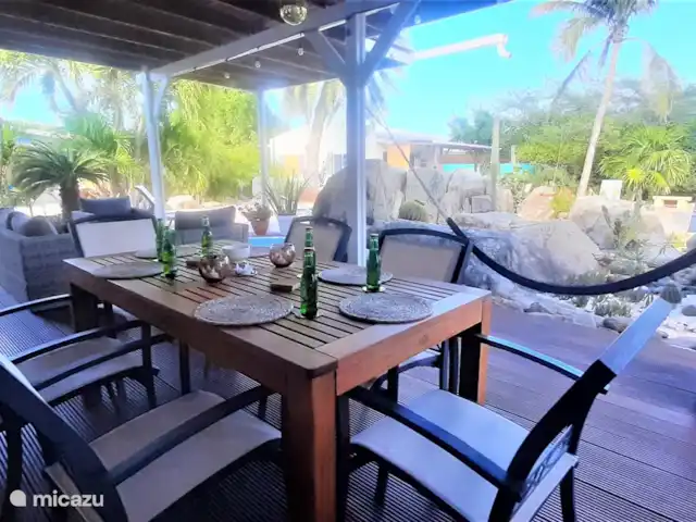 Villa de lujo con hermoso jardín en Aruba, Paradera, Paradera - villa Veranda con jacuzzi, mesa de comedor y juego de salón.