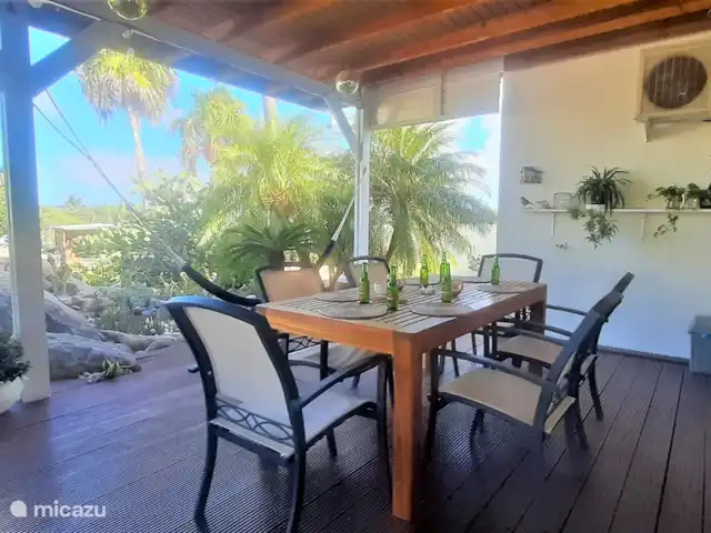 Villa de lujo con hermoso jardín en Aruba, Paradera, Paradera - villa Veranda con jacuzzi, mesa de comedor y juego de salón.