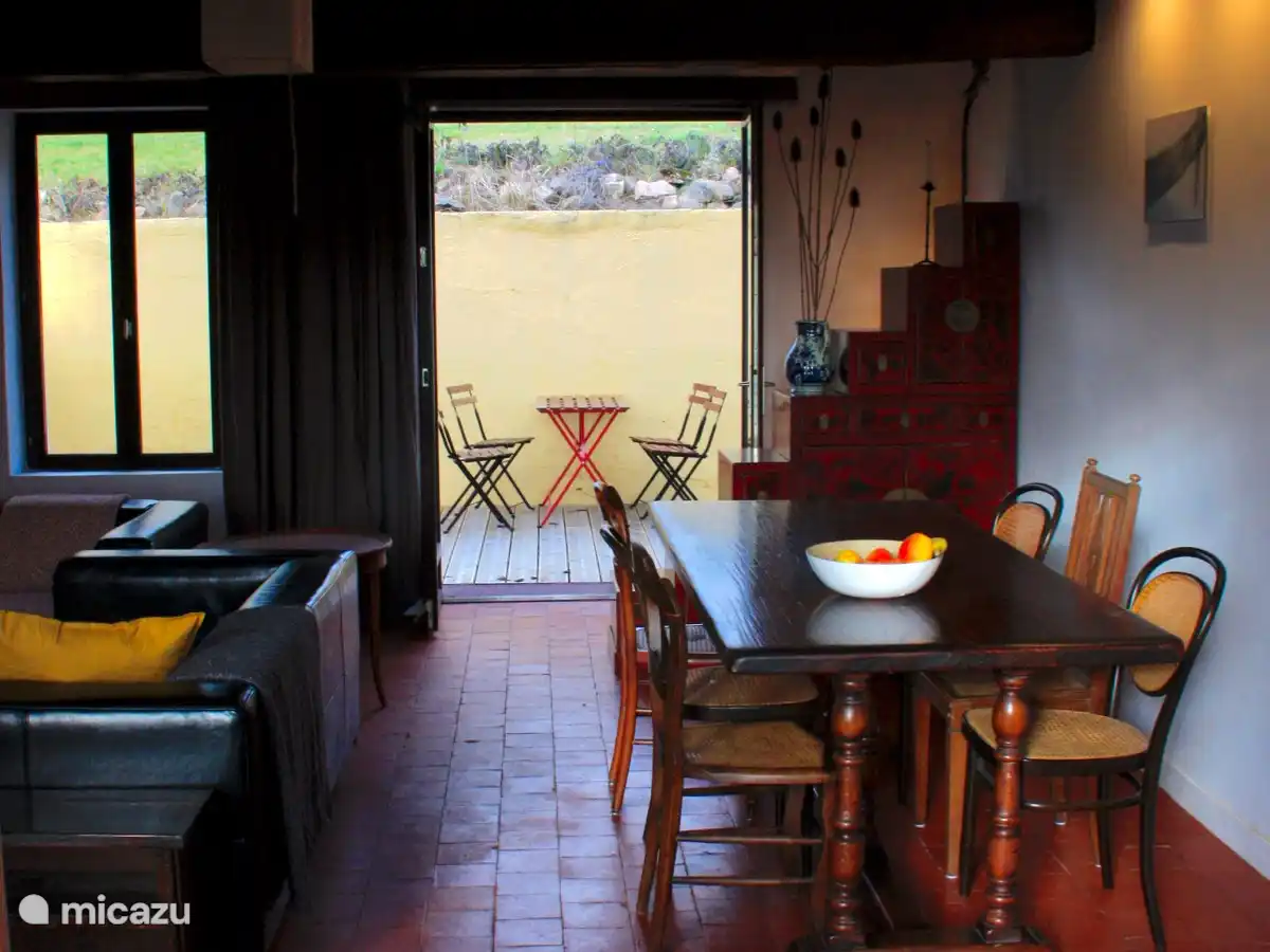 A large table for games or dining together, and passage to the rear terrace