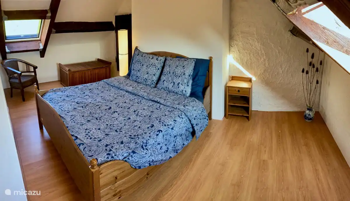 The bedroom on the first floor has two windows overlooking the meadow behind the house and the hills in front of the house.