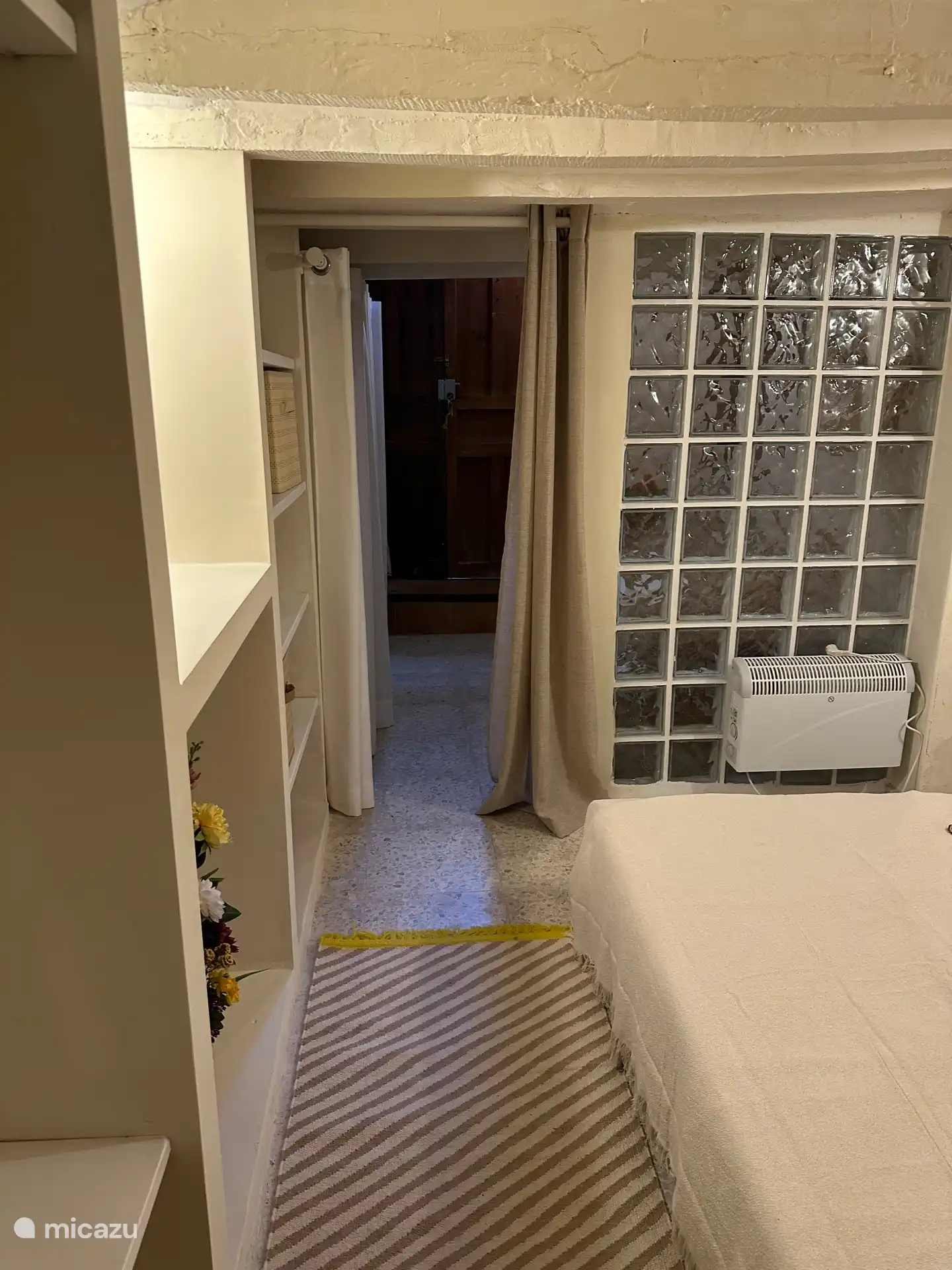 Entree met voordeur, hierachter de slaapruimte met badkamer