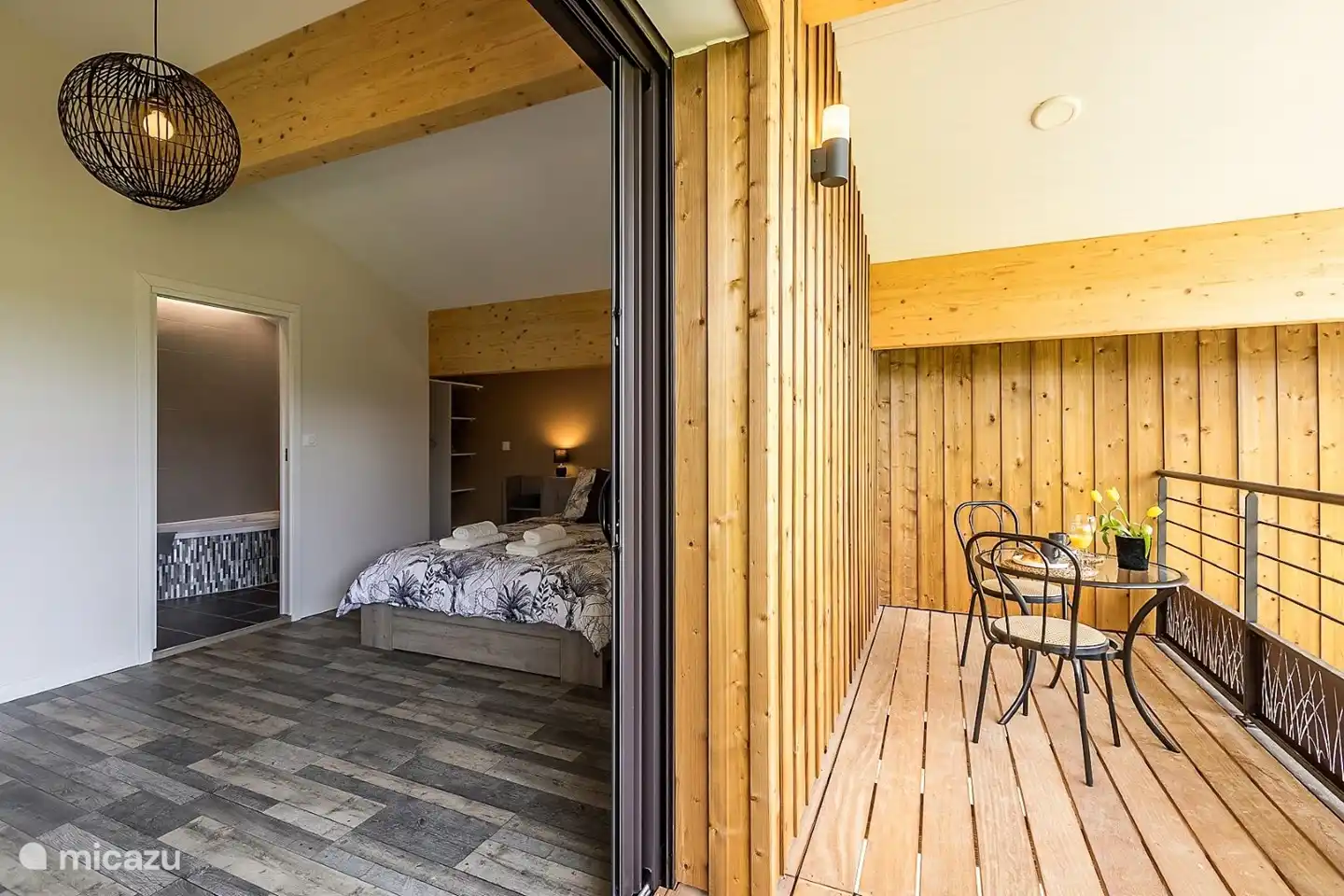 Das Schlafzimmer mit Zugang zum Balkon mit Sitzgelegenheit