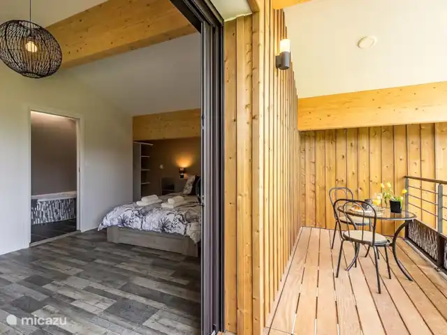 Casa de diseño ecológico Ducarinne en Francia, Lot y Garona, Argenton - villa El dormitorio con acceso al balcón con asientos.