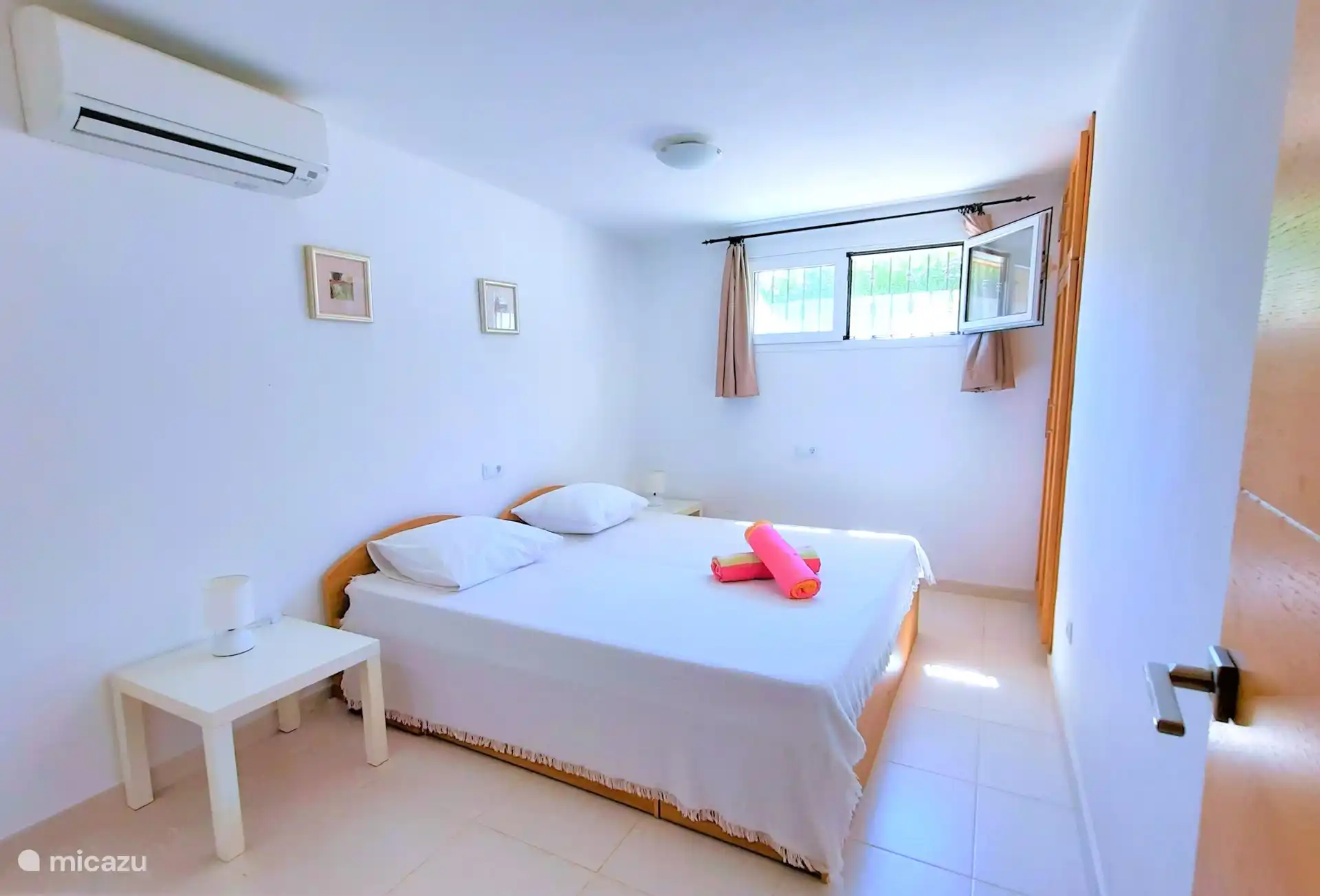 Spacious bedroom 4 on the ground floor with air conditioning, built-in wardrobe and mosquito net