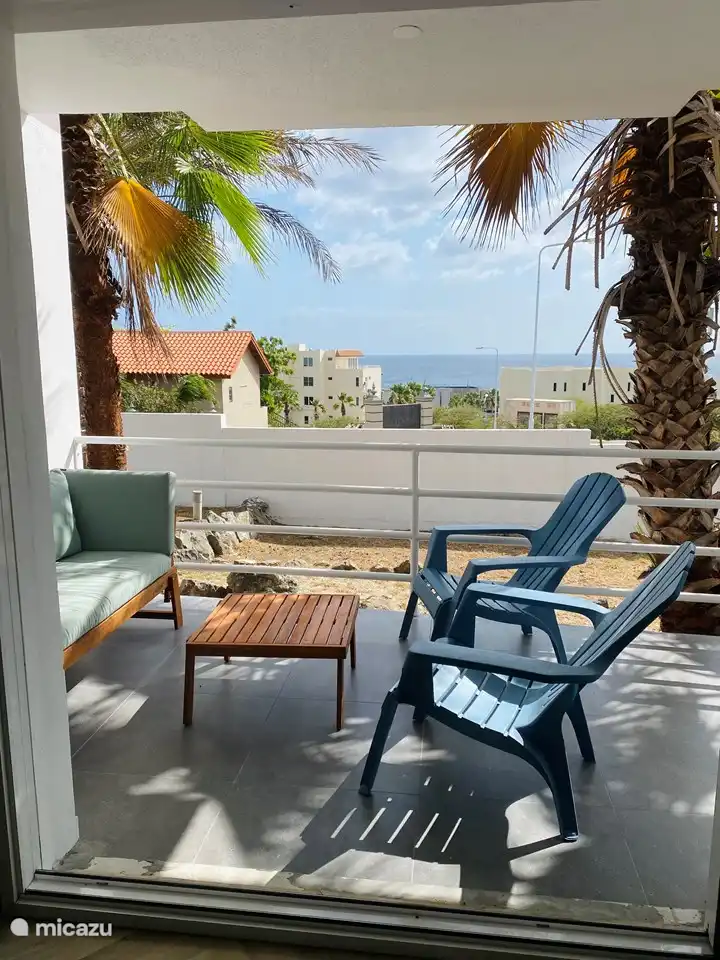 Patio with lounge set and dining area, which offers a view over the sea.