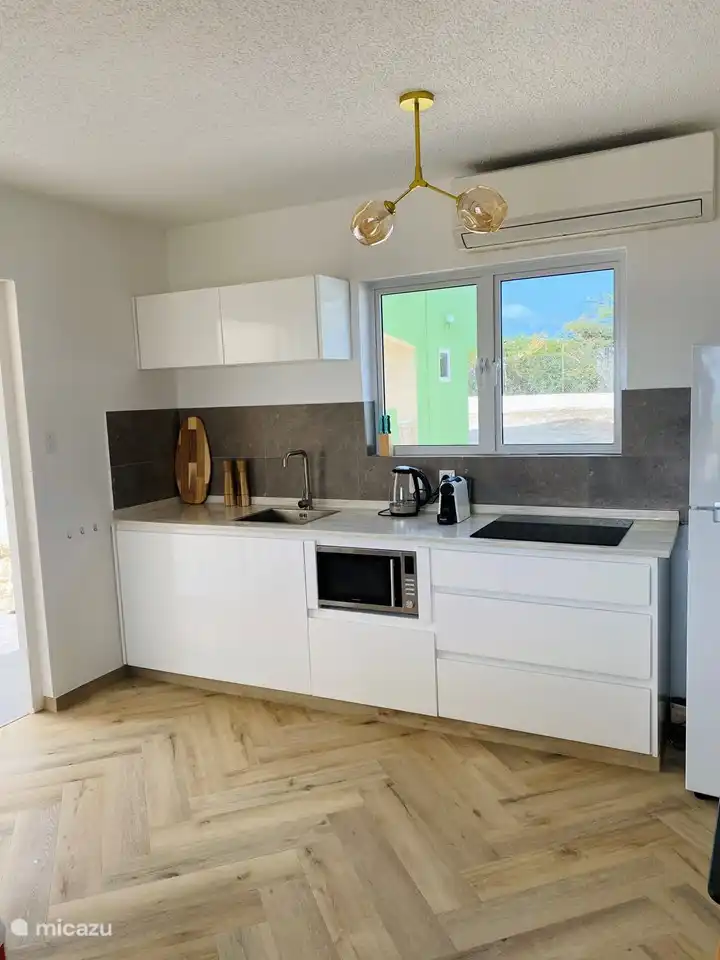 Kitchen with fridge with freezer, microwave and Nespresso machine.
