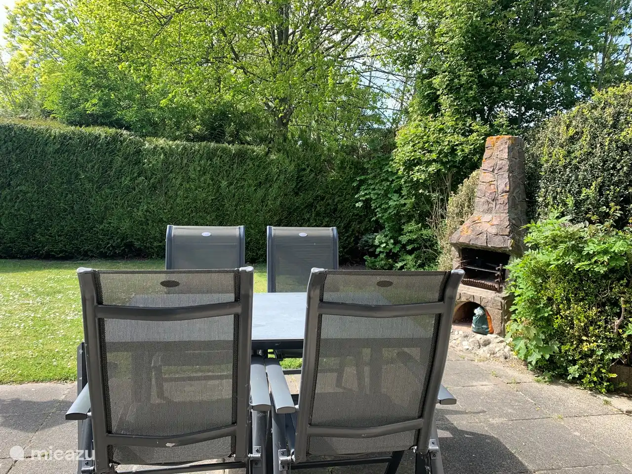 Joli jardin avec cheminée/barbecue, 2 chaises longues, beaux parasols, table à manger et 4 chaises de jardin