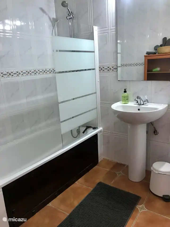Geräumiges zweites Badezimmer mit Badewanne/Dusche, Waschbecken, Badezimmerschrank und Toilette.