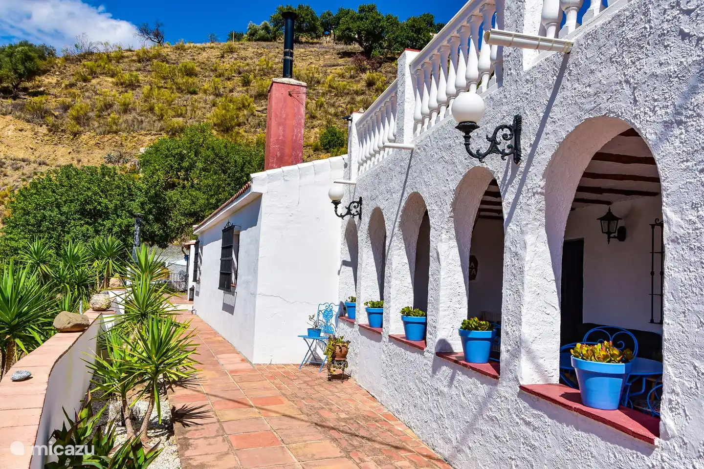 Überdachte Terrasse und Dachterrasse. Weg entlang des Hauses zur geräumigen Außenküche und zum Poolgarten.