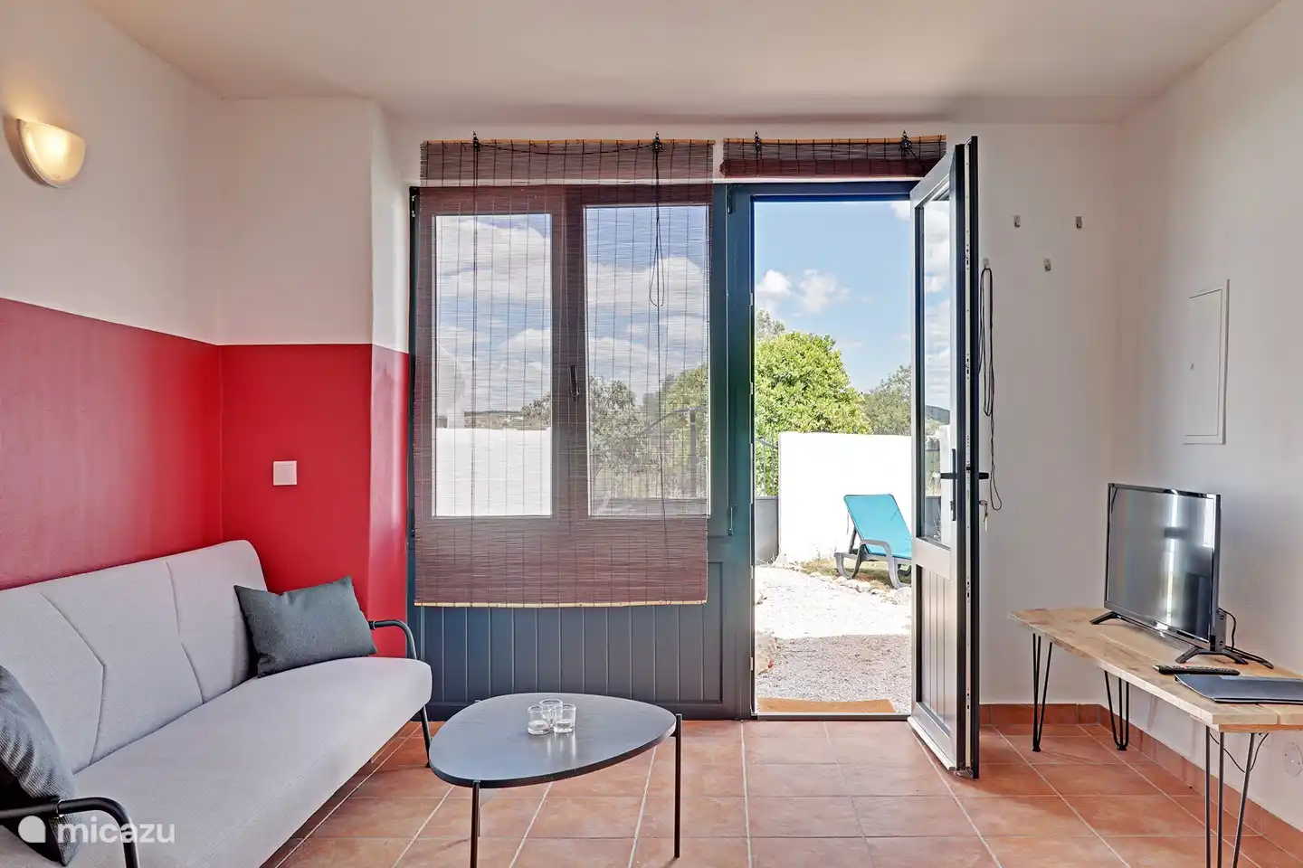 Eine gemütliche Sitzecke mit Fernseher und Blick in den Garten.