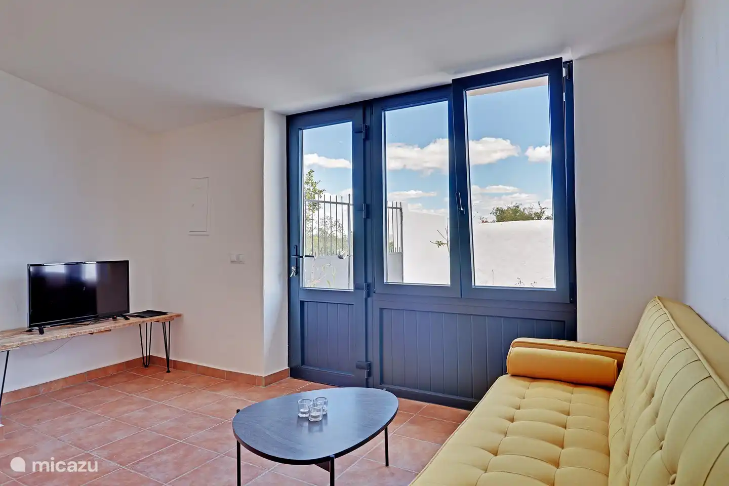 Eine gemütliche Sitzecke mit Fernseher und Blick in den Garten.