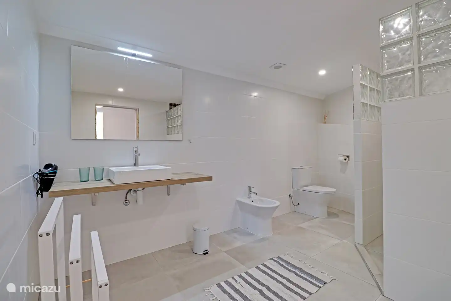 Das geräumige Badezimmer hat eine schöne Regendusche und ein Bidet.