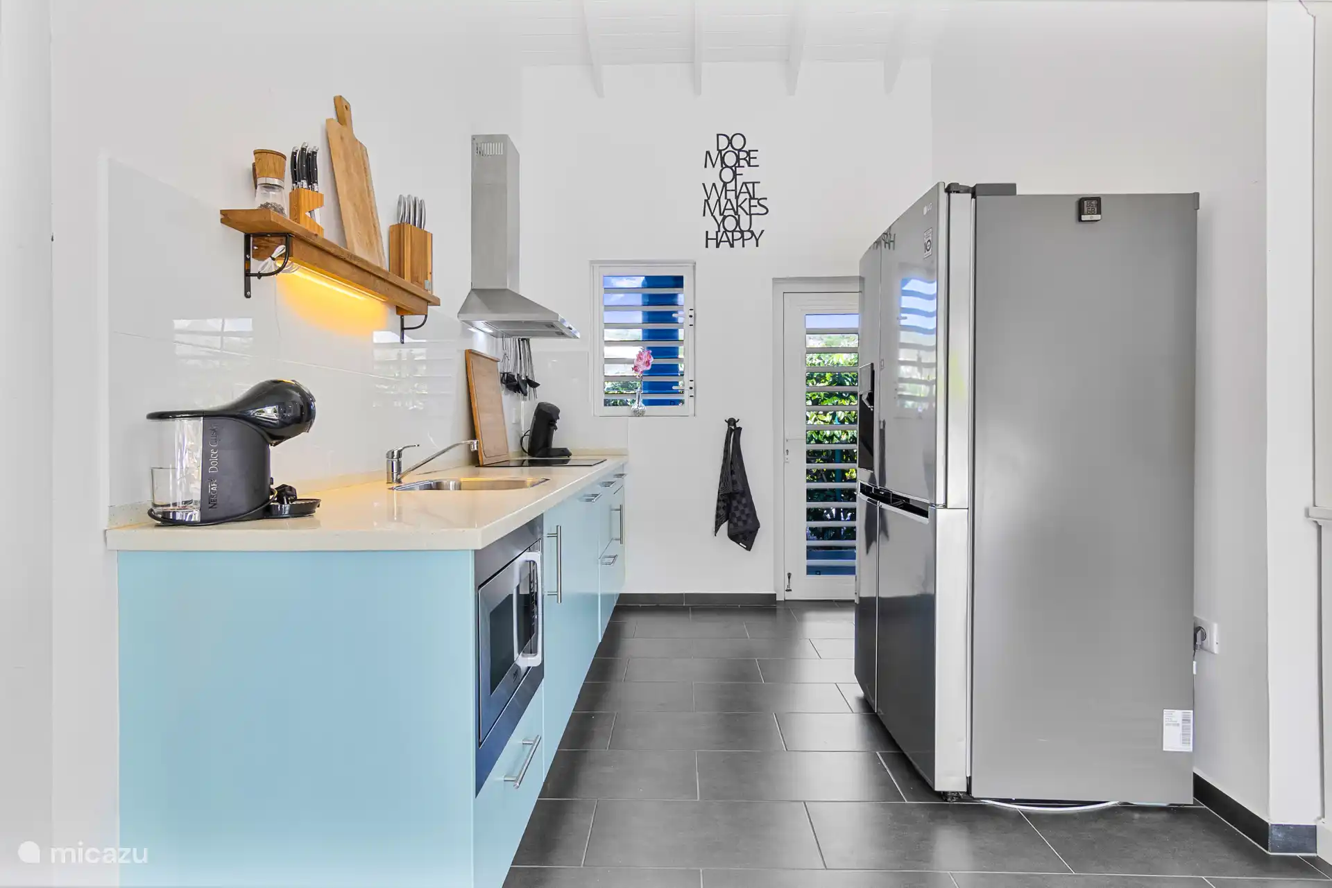 La cocina abierta con varios electrodomésticos, incluyendo lavavajillas, frigorífico americano, microondas combinado, etc.