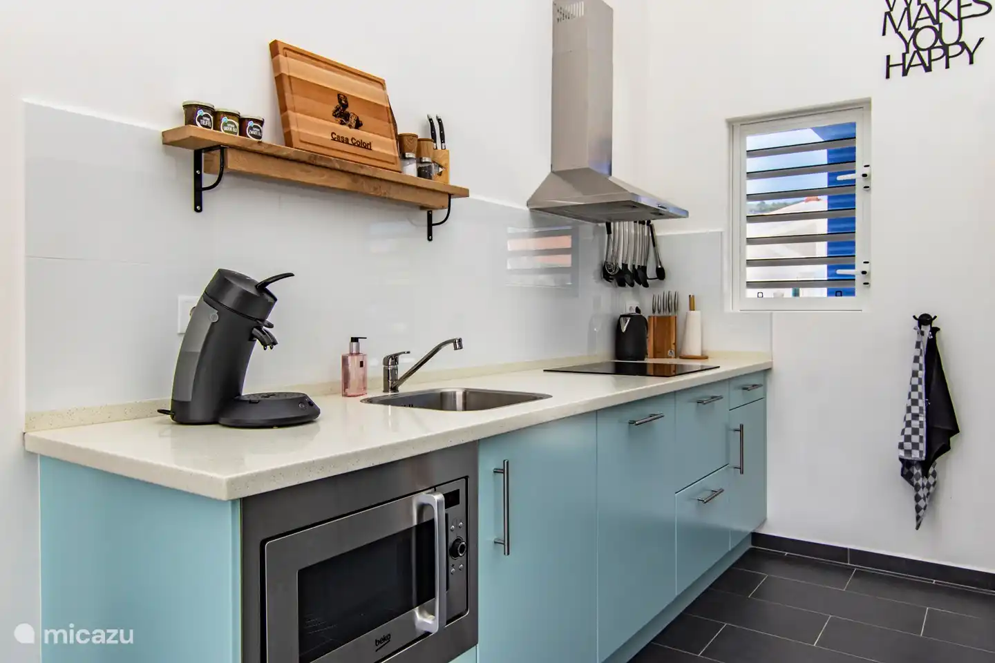 Cocina con varios electrodomésticos y nevera americana